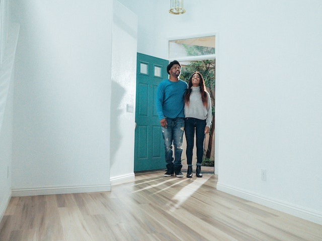 two prospective tenants taking a tour of an unfurnished home